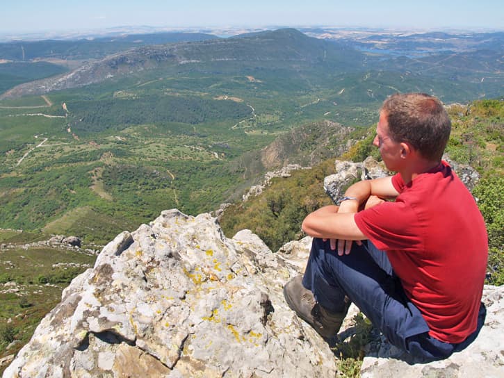 A man on top a mountain looking at the horizon